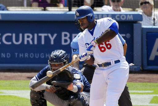 Los Angeles Dodgers Yasiel Puig right hits a three-run home run as San Diego Padres catcher Hector Sanchez watches during the third inning of a baseball game Sunday Sept. 4 2016 in Los Angeles