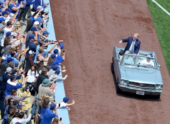 Vin Scully waves to fans from a car