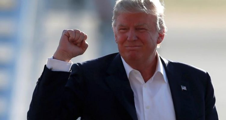 U.S. Republican presidential candidate Donald Trump pumps his fist as he arrives to speak at a campaign rally in Sacramento California