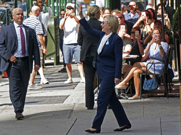 Democratic presidential candidate Hillary Clinton walks from her daughter's apartment building Sunday Sept. 11 2016 in New York. Clinton unexpectedly left