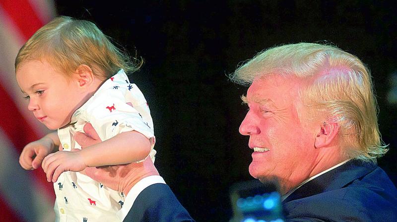 Donald Trump holds a baby at a campaign event