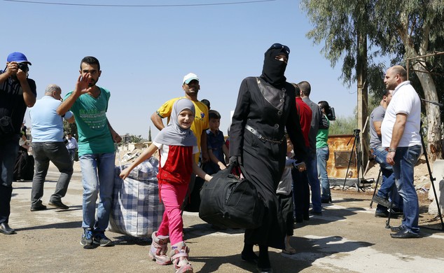 Syrians leave the Moadamiyeh suburb of Damascus Syria on Friday Sept. 2 2016. Dozens of Syrians living in a besieged rebel-held suburb of the capital Da