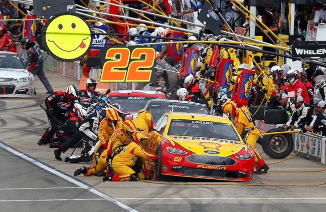 Joey Logano's crew changes tires during a pit stop in a NASCAR Sprint Cup Series auto race at Michigan International Speedway in Brooklyn Mich. Sunday Aug. 28 2016