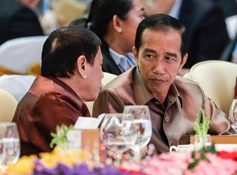 Philippine President Rodrigo Duterte listens to Indonesian President Joko Widodo, during the gala dinner of the Association of Southeast Asian Nations Summit at the National Convention Center in Vientiane Laos 07 September 2016