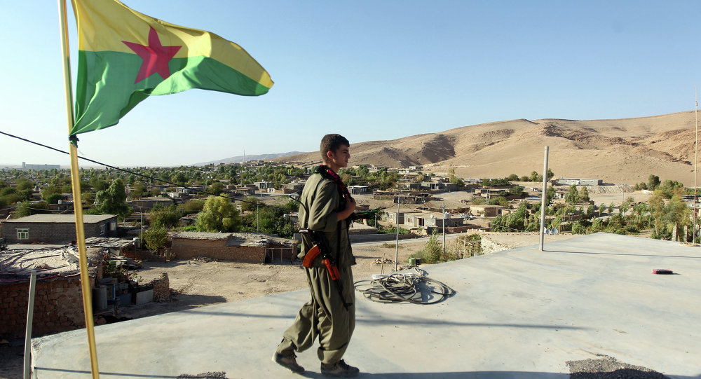 A Kurdistan Workers Party fighters guards a post flying the PKK flag. File