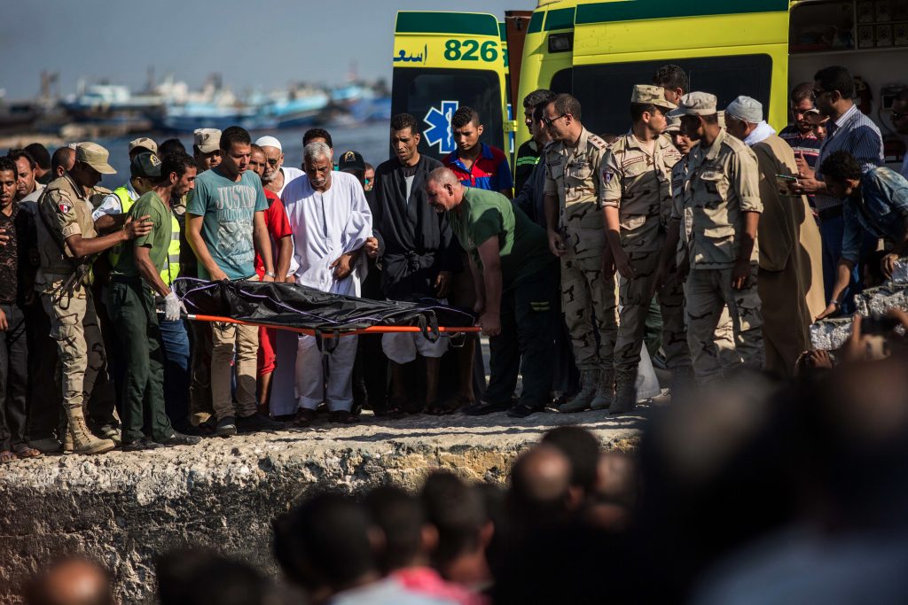 Egyptian Coast Guard and rescue workers bring a body ashore in Rosetta Egypt on Thursday