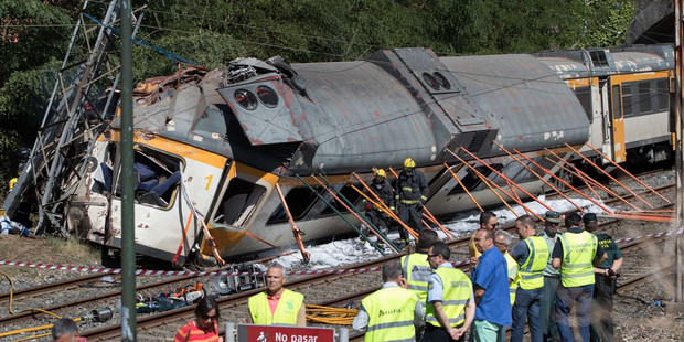 Emergency personnel attend the scene after a passenger train derailed in Spain