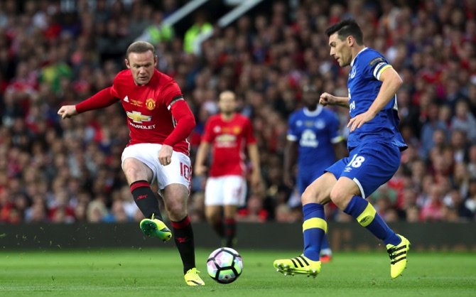 Everton’s Gareth Barry, attempts to block Manchester United’s Wayne Rooney during testimonial match for Rooney at Old Trafford Manchester on August 3