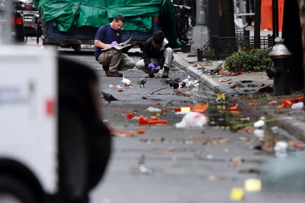 Evidence teams investigate at the scene of Saturday's explosion in Manhattan's Chelsea neighbourhood