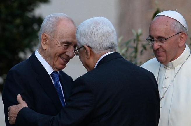 Israeli President Shimon Peres shakes hands with Palestinian leader Mahmud Abbas as Pope Francis looks on following a peace summit at the Vatican