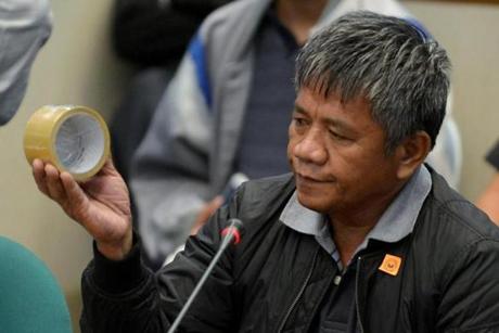 Edgar Matobato holds a roll of tape the type of which he says he used on his victims during a Senate hearing