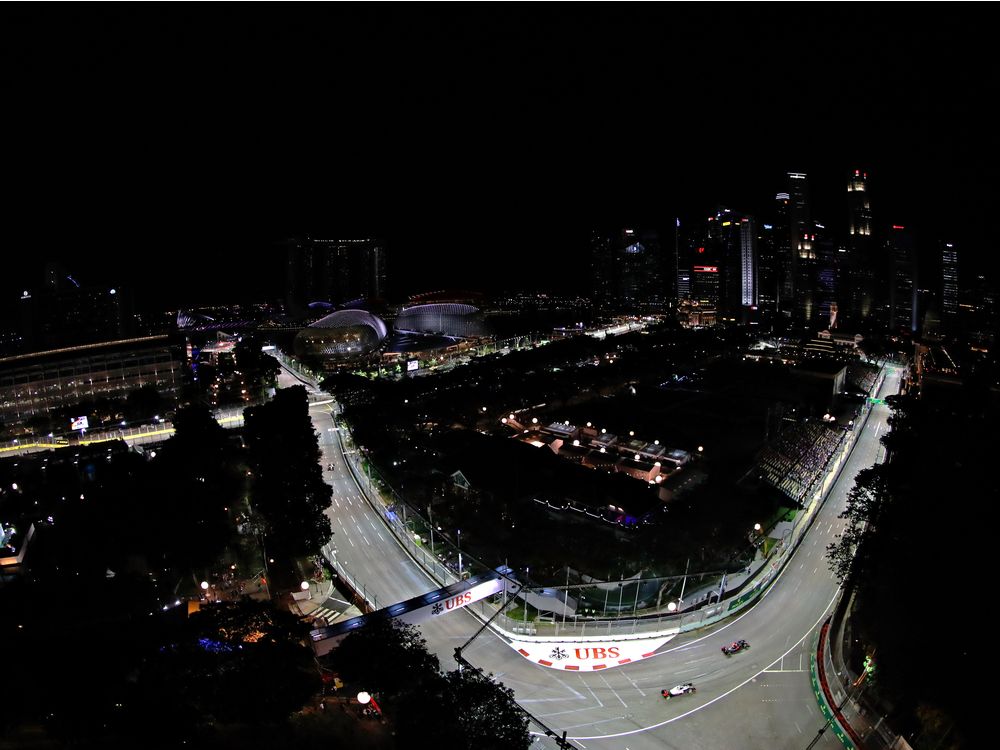 SINGAPORE- SEPTEMBER 16 Fernando Alonso of Spain driving the Mc Laren Honda Formula 1 Team Mc Laren MP4-31 Honda RA616H Hybrid turbo leads Romain Grosjean of France driving the Haas F1 Team Haas Ferrari VF-16 Ferrari 059/5 turbo on track during