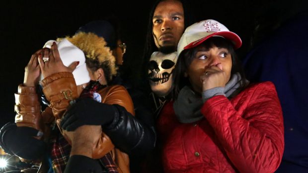 Darren Seals centre stands behind Michael Brown's mother Lezley Mc Spadden outside the Ferguson police station in 2014