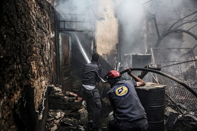 Firefighters extinguish a fire following an airstrike in the rebel-held area of Douma outskirts of Damascus