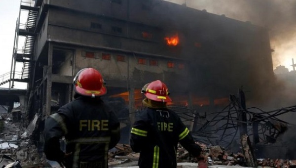 Firefighters stand at the site of a fire at a packaging factory outside Dhaka Bangladesh Sept. 10 2016