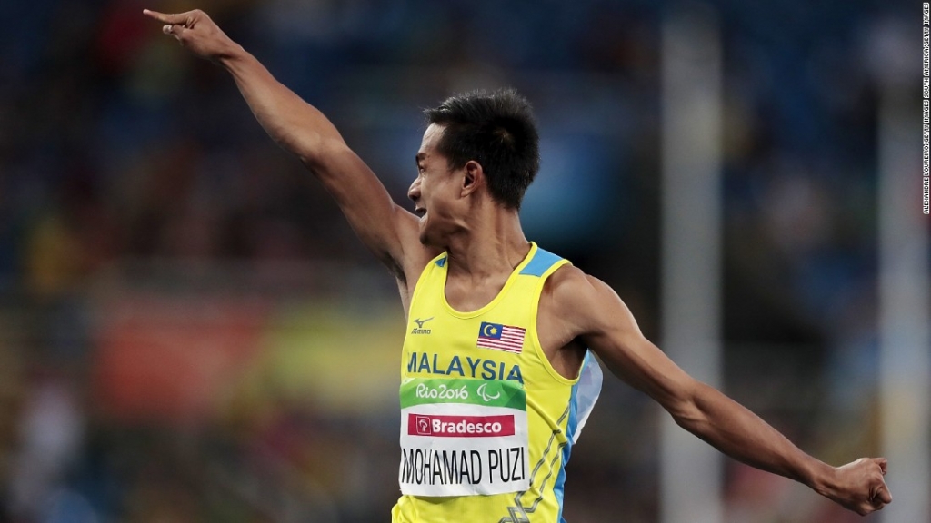 Mohamad Ridzuan Puzi celebrates as he crosses the line in the T36 100m final winning Malaysia's first ever Paralympic gold medal