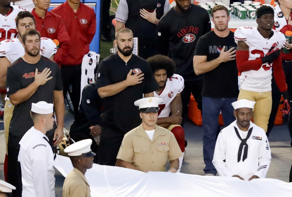 San Francisco 49ers quarterback Colin Kaepernick middle kneels during the national anthem before the team's NFL preseason football game against the San Diego Chargers Thursday Sept. 1 2016 in San Diego. ORG XMIT CACC10