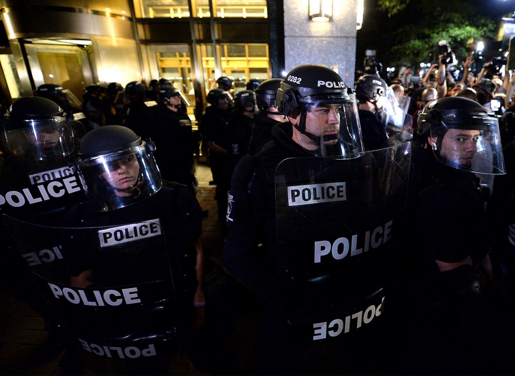 Police officers in riot gear stand by as protesters gather in Charlotte N.C. on Thursday Sept. 22 2016. The curfew has ended for Friday in Charlotte following a night of mostly peaceful protests of the shooting of Keith Lamont Scott by an officer. Char