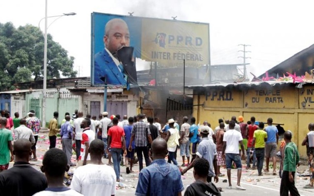 Congolese opposition supporters chant slogans as they destroy the billboard of President Joseph Kabila during a march to press the President to step down in the Democratic Republic of Congo's capital Kinshasa