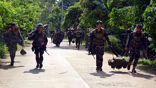 Soldiers walk along a highway as they return to camp after an armed encouter with members of militant group Abu Sayyaf at the village of Bongkaong Patikul town Sulu province on the southern island of Mindanao in this