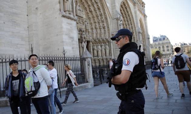 A French police officer patrols in front of Notre Dame cathedral in Paris Friday Sept. 9 2016. A failed attack involving a car loaded with gas canisters near Notre Dame Cathedral was spearheaded a group of women that included a 19-year-old whose writte