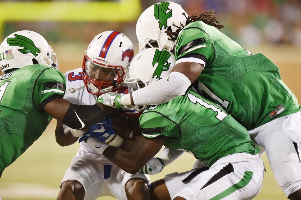 North Texas safety James Gray, cornerback Chad Davis and linebacker Cortney Finney tackle SMU wide receiver James Proche earlier this season at Apogee Stadium. UNT will take on Florida this Saturday