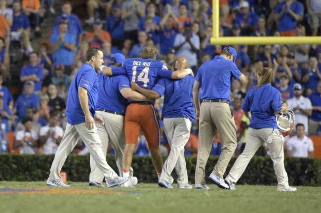 Florida quarterback Luke Del Rio is helped off the field after injuring his leg during the second half against North Texas in Gainesville on Saturday