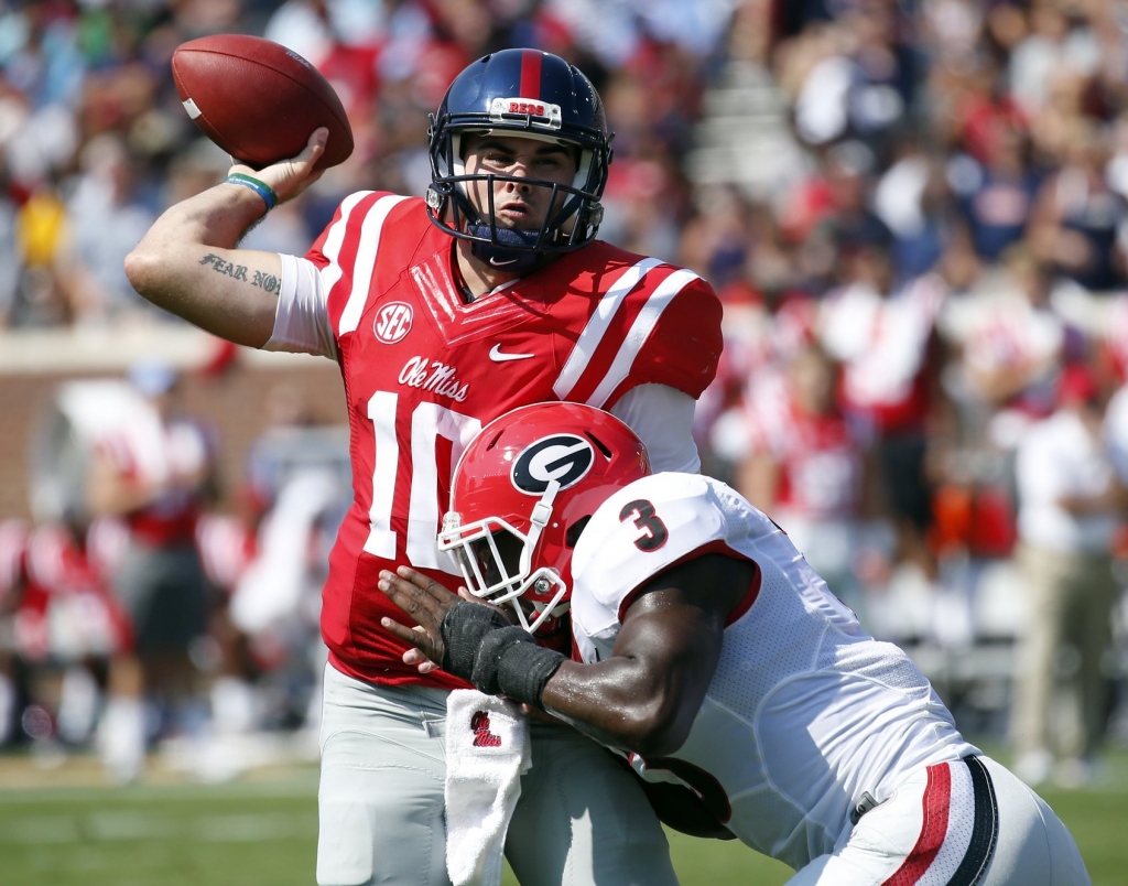 Mississippi quarterback Chad Kelly manages to make a pass as he is hit by Georgia linebacker Roquan Smith in the first half of their NCAA college football game Saturday Sept. 24 2016 in Oxford Miss