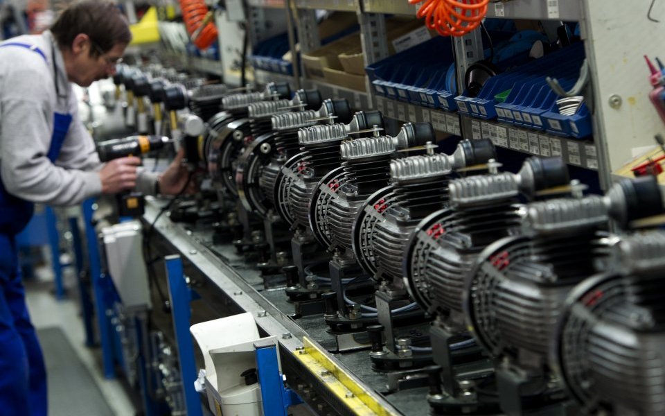 A man works on a compressors production