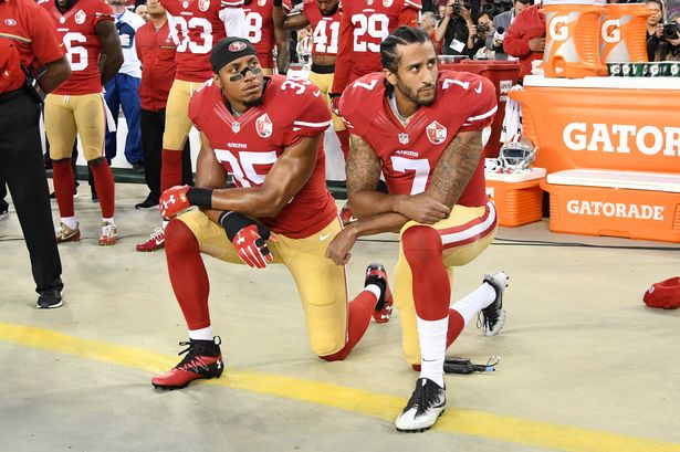 Colin Kaepernick #7 and Eric Reid #35 of the San Francisco 49ers kneel in protest during the national anthem