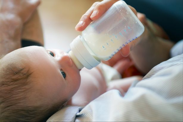 Newborn baby being fed from a bottle