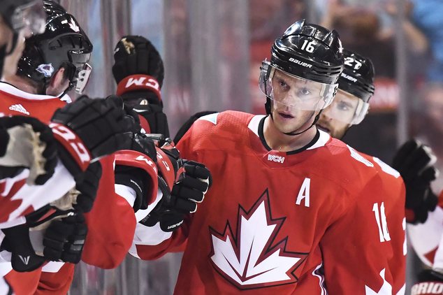 Team Canada's Jonathan Toews celebrates his second goal of the game against Team Europe with teammates on the bench during the second period of a World Cup