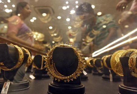 Gold bracelets are on display as a woman makes choices at a jewellery showroom in Kolkata