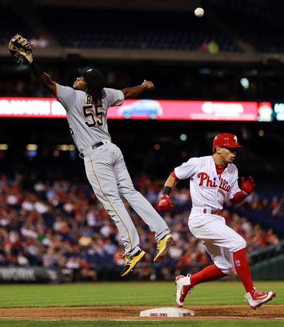 Philadelphia Phillies&#39 Cesar Hernandez right reaches first base on a bunt as Pittsburgh Pirates first baseman Josh Bell leaps for a wild throw during the fourth inning of a baseball game Wednesday Sept. 14 2016 in Philadelphia. Hernandez advance