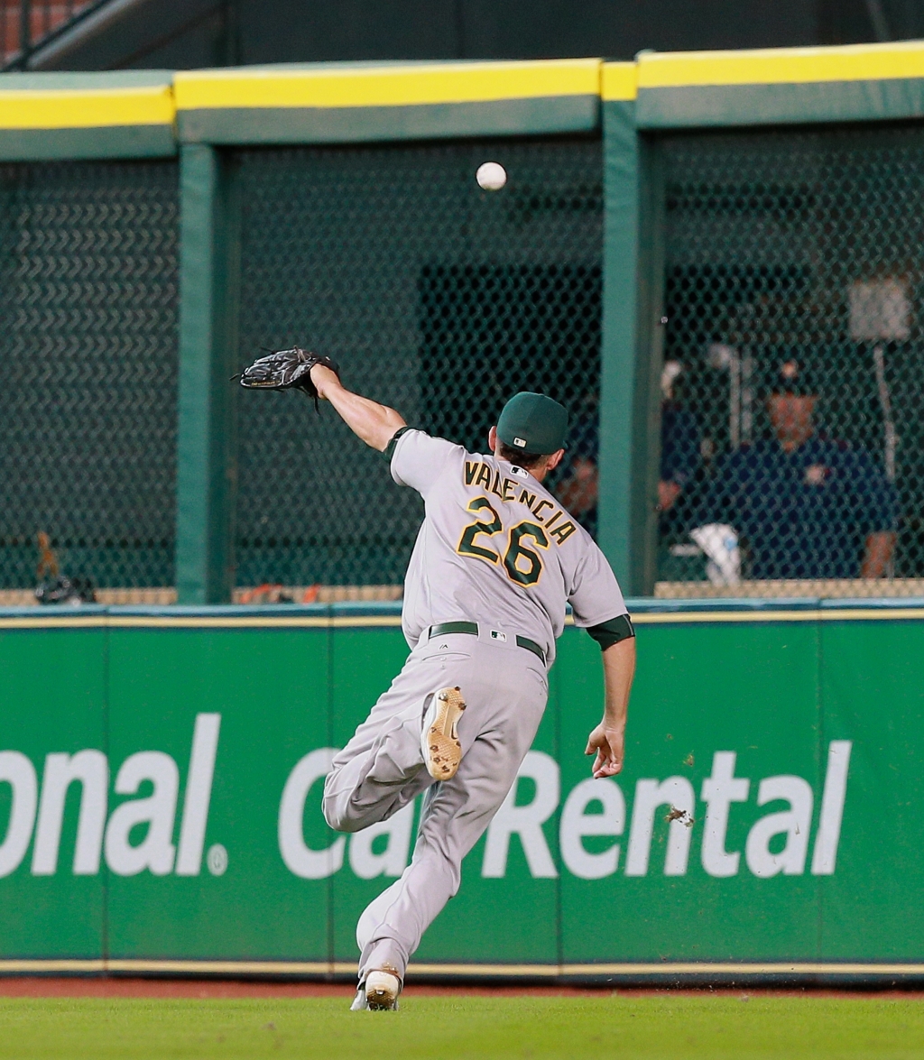 Danny Valencia #26 of the Oakland Athletics can't track down a line drive by Jose Altuve #27 of the Houston Astros in the eighth inning at Minute Maid Park