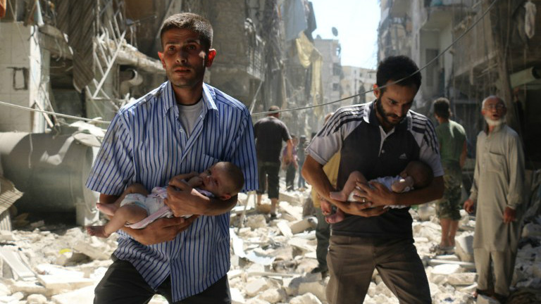 Syrian men carrying babies make their way through the rubble of destroyed buildings following a reported air strike on the rebel-held Salihin neighborhood of the northern city of Aleppo