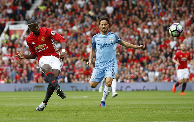 Manchester United's Paul Pogba shoots the ball during the English Premier League football match against Manchester City at Old Trafford on Saturday