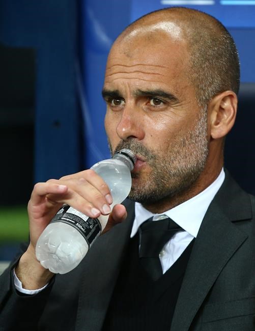 Manchester City's manager Pep Guardiola takes a drink of water prior to the start of the Champions League group C soccer match at the Etihad Stadium between Manchester City and Borussia Moenchengladbach in Manchester England Wednesday Sept. 14 201