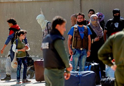 Gunmen from the besieged neighborhood of Al Waer prepare to leave the last rebel-held neighborhood of Homs Syria