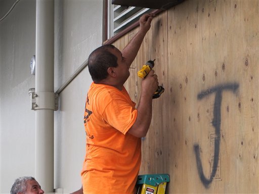 Giuseppe Manone boards up the windows of a store in Hilo Hawaii as Hurricane Madeline approached the Big Island on Wednesday Aug. 31 2016. Drier air and strong upper atmosphere winds are weakening Hurricane Madeline as it approaches Hawaii. (AP