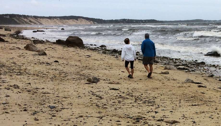 A couple walk along Sagamore Beach as Hermine now a tropical storm whips up heavy surf on Cape Cod Bay in Bourne Mass