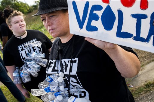 Flint resident Maegan Wilson right joins dozens gathered to protest Republican presidential candidate Donald Trump's visit on Wednesday Sept. 14 2016 outside of the Flint Water Plant in Flint Mich