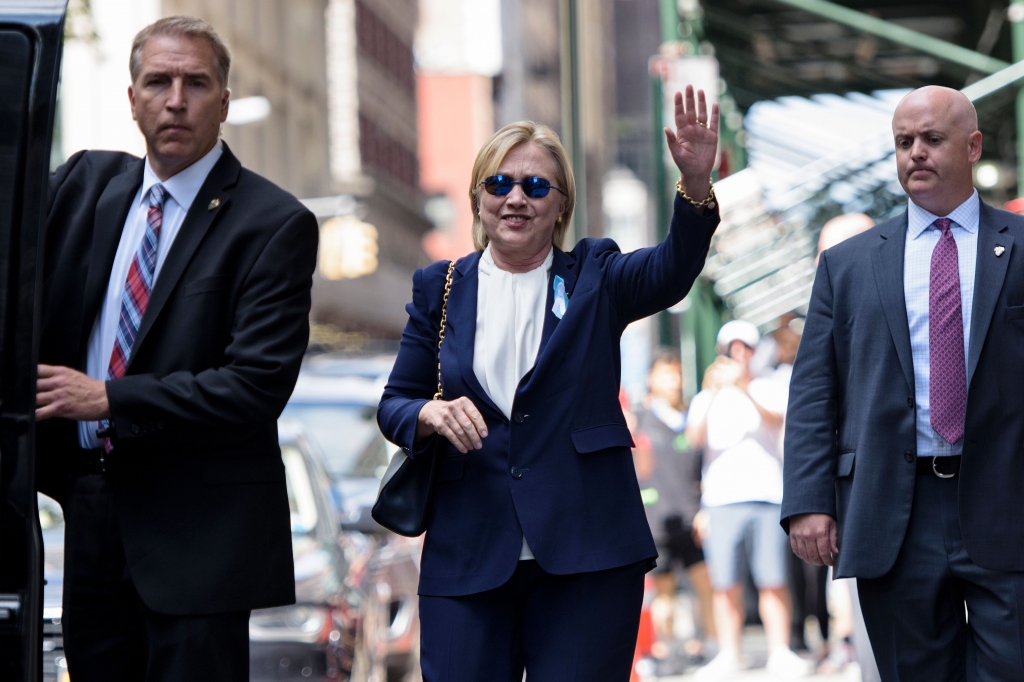 Hillary Clinton waves to press