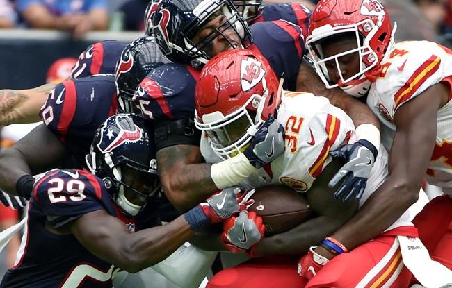 Kansas City Chiefs running back Spencer Ware is wrapped up by Houston Texans free safety Andre Hal and linebacker Benardrick Mc Kinney during the second half of an NFL football game Sunday Sept. 18 2016 in Houston. (AP