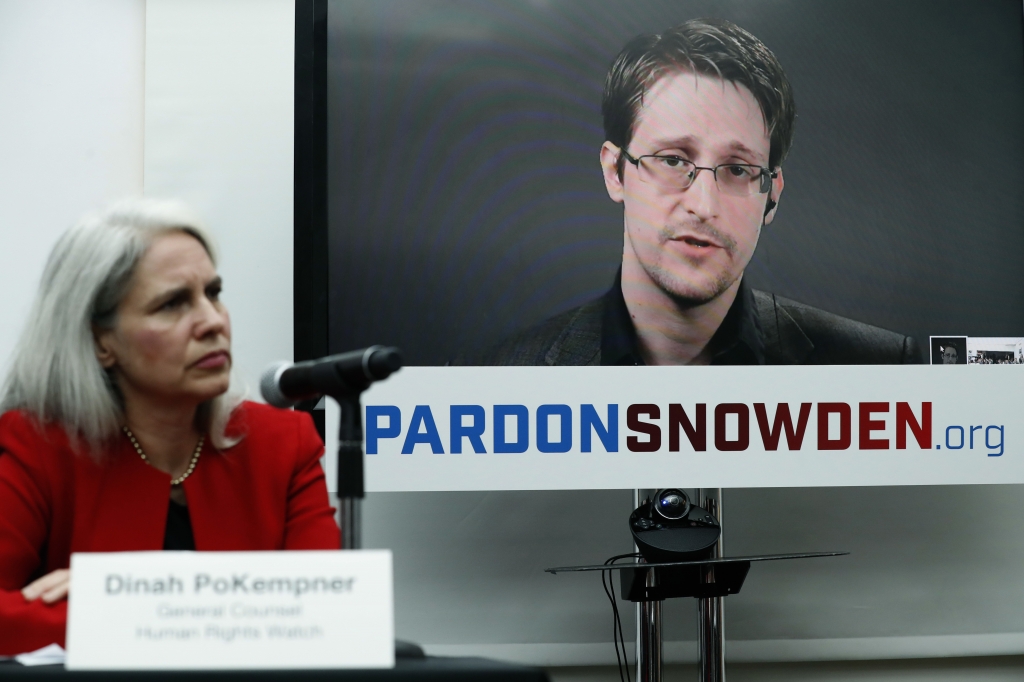 Dinah PoKempner left general council for Human Rights Watch listens as Edward Snowden speaks on a television screen via video link from Moscow during a Wednesday news conference to call upon President Barack Obama to pardon Snowden before he leaves off