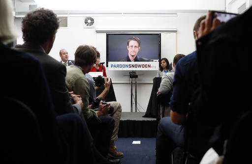 Edward Snowden is seen on a television screen via video uplink from Moscow during a news conference to call upon President Barack Obama to pardon Snowden before he leaves office Wednesday Sept. 14 2016 in New York. Human and civil rights organizations