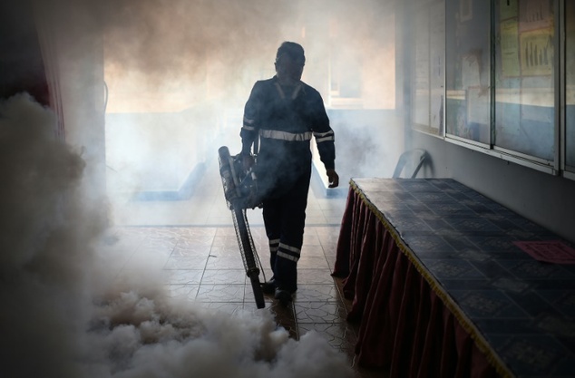 A pest control worker fumigates a school classroom on the eve of the annual national Primary School Evaluation Test in Kuala Lumpur