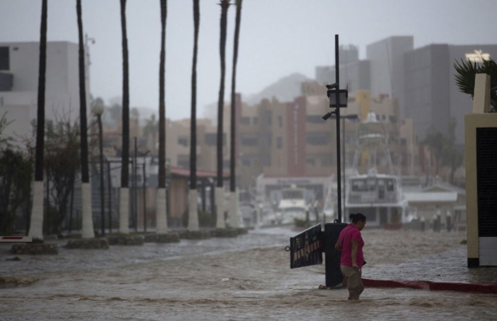 A woman wades through a street flooded by the heavy rains brought on by Hurricane Newton in Cabo San Lucas Mexico Tuesday Sept. 6 2016