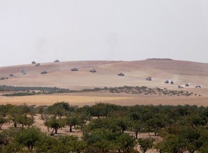 Turkish army tanks and Turkish-backed Syrian fighters make their way in the Syrian border town of Jarablus as it