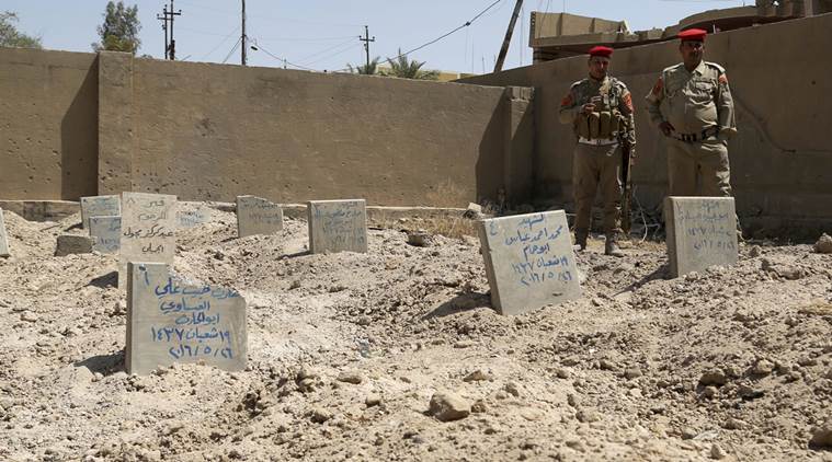 Iraqi security forces inspect a school yard used as a cemetery for killed Islamic State group fighters in Fallujah 40 miles west of Baghdad Iraq